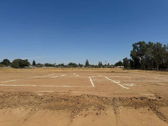Graded building pad with the layout staked out for a new home