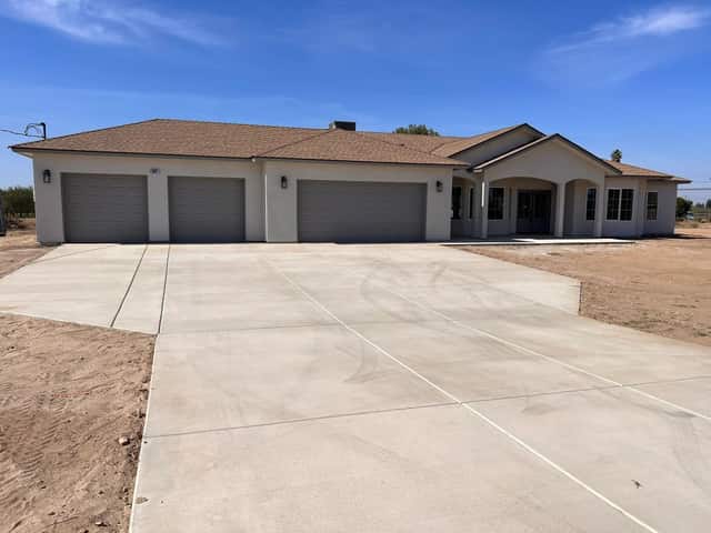 Completed single story home with a three car garage and a new concrete driveway