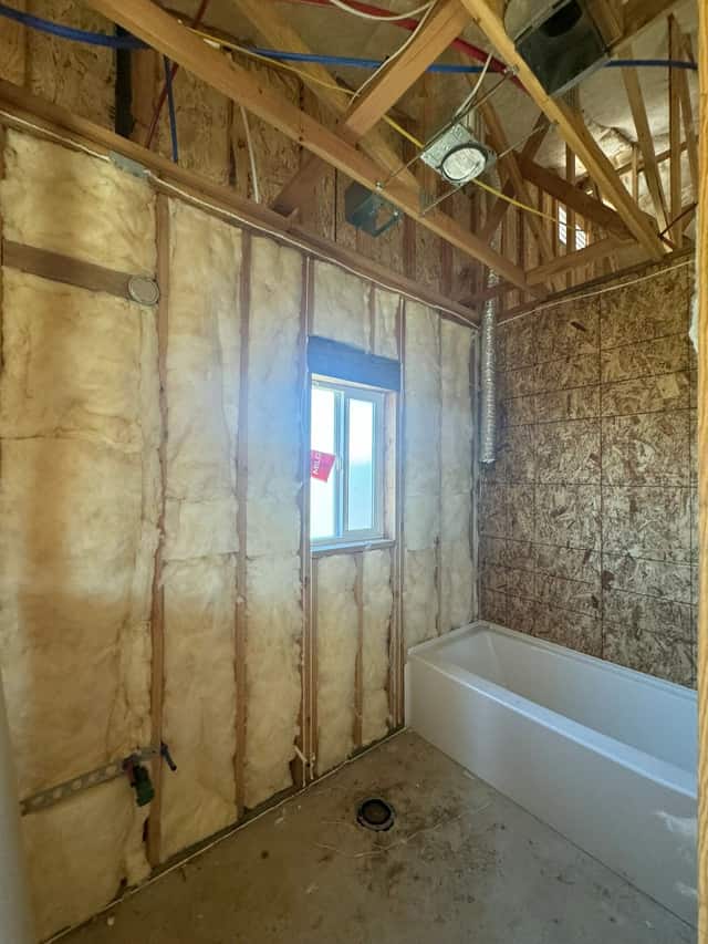 Framed bathroom with the tub set in place and insulation installed