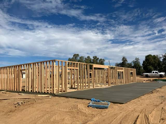 Exterior wall framing standing on the slab of a custom home under construction