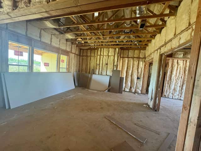 Interior framing with insulation installed and drywall staged for hanging