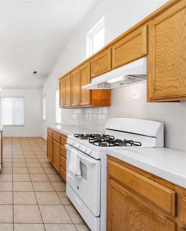 Original oak cabinet kitchen with a white range, photographed before an Almond Grove Homes remodel