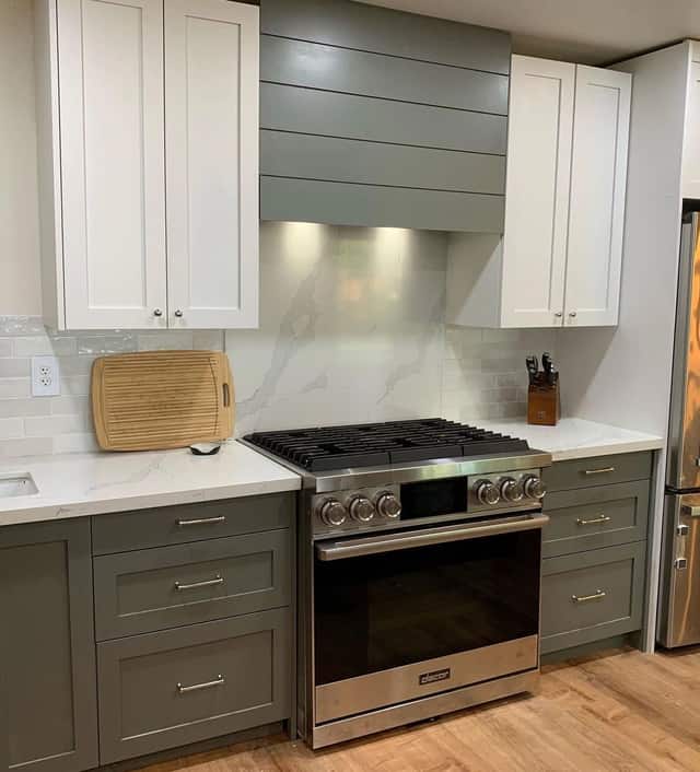 Remodeled kitchen with green shaker cabinets, a stainless steel range, and quartz countertops