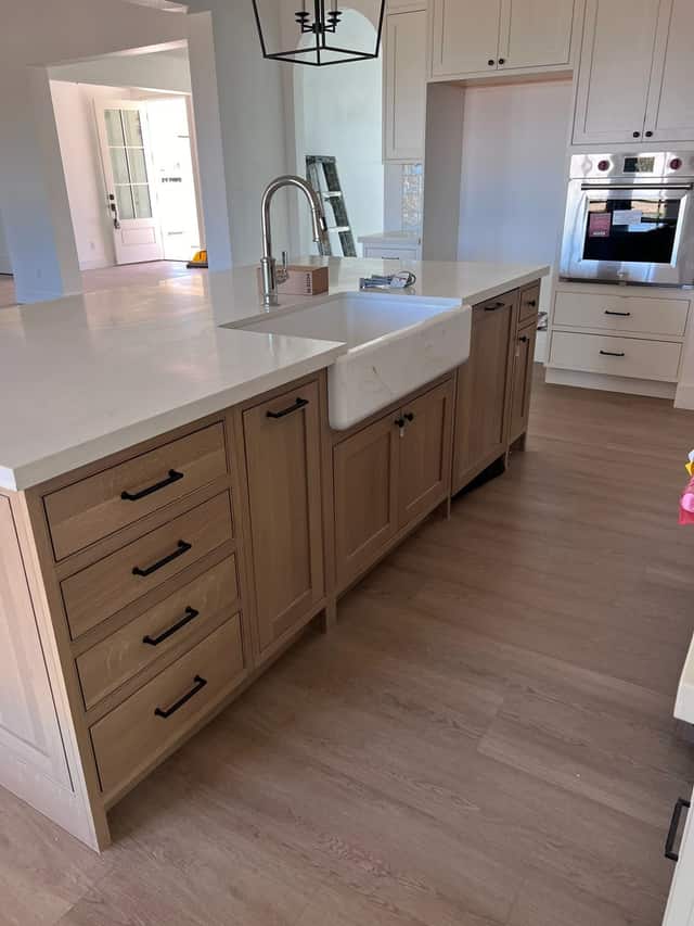Kitchen island with a farmhouse sink and natural wood cabinetry