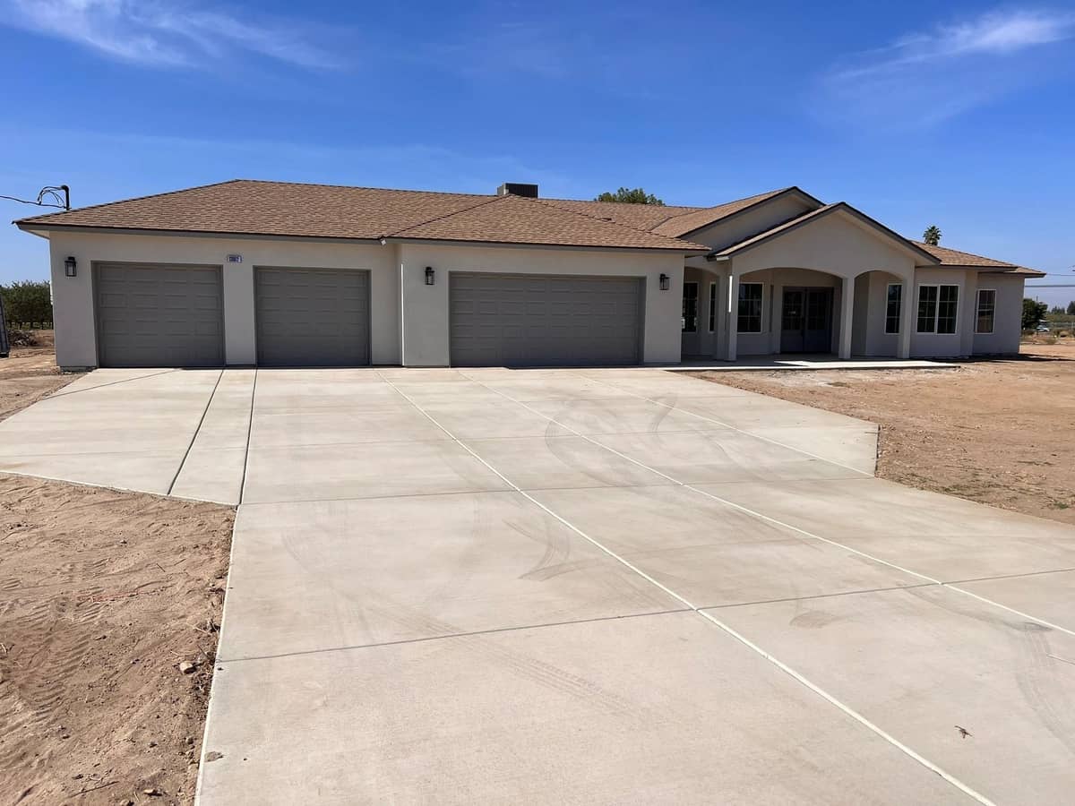 Completed single story home with a three car garage and a new concrete driveway